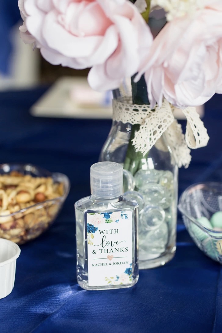 Wedding favor bottle with blush florals on a navy linen
